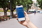 Eine Person hält ein Smartphone mit der digitalen Versichertenkarte der BGN in der Wallet-App in der Hand