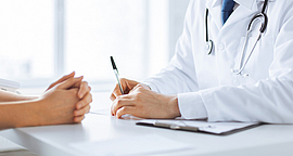 Arzt macht sich Notizen währen eines Patientengesprächs