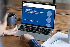 Eine Person sitzt vor einem Notebook und nimmt an einem Onlinemeeting teil