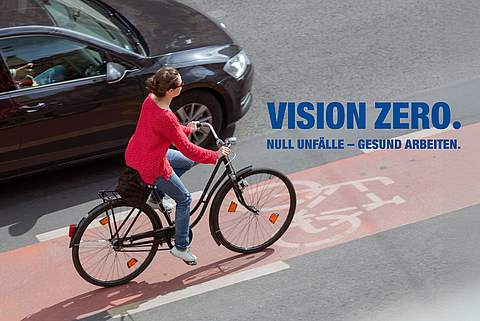 Frau fährt Fahrrad auf einem Radweg in der Nähe von Verkehr