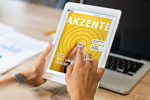 Eine Frau betrachtet das Magazin Akzente als Blätterkatalog auf einem Tablet